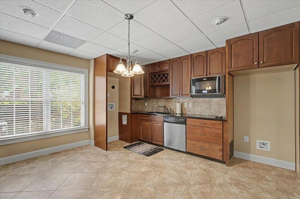 122 Ridge View Drive Ball Ground, GA 30107 - Photo 53 of 84 a kitchen with stainless steel appliances granite countertop a refrigerator a sink dishwasher a dining table and chairs with wooden floor