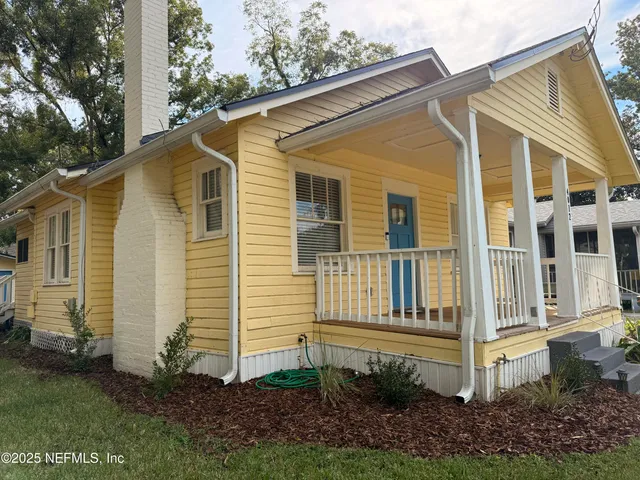 a view of a wooden house with a yard