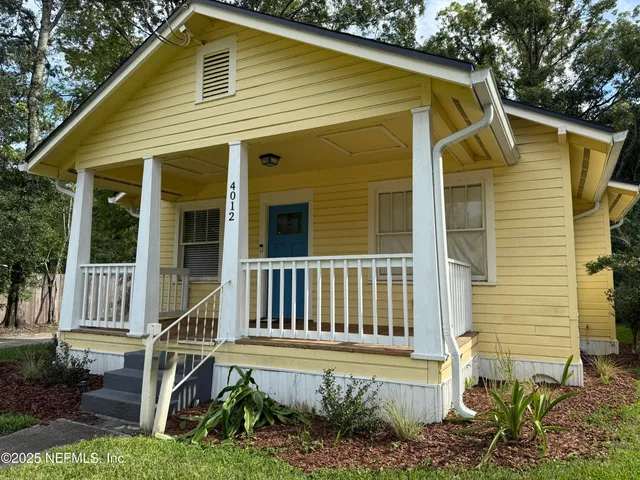 a view of a house with a small deck and a garden
