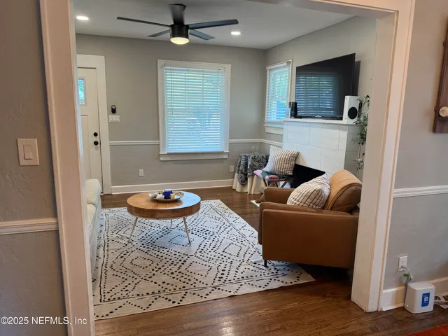 a living room with furniture a flat screen tv and a window