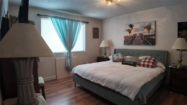 a bedroom with a bed next to a window