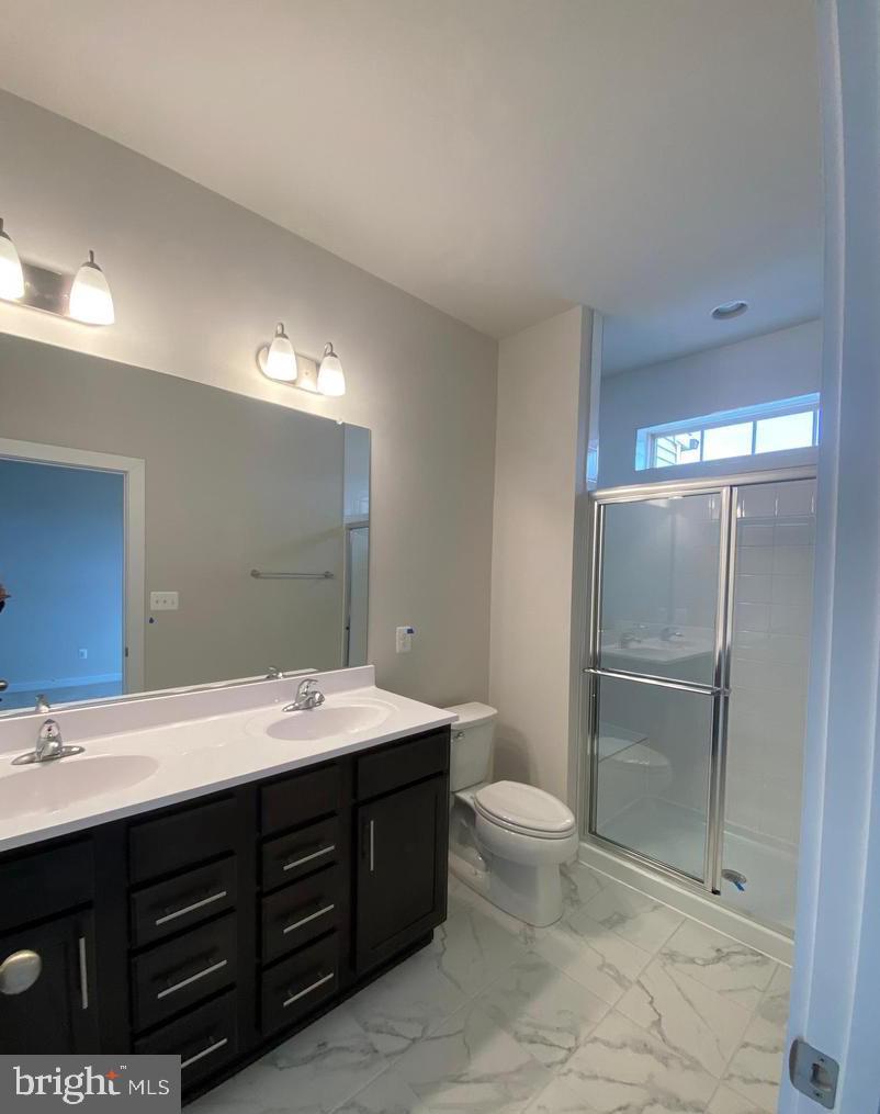 3639 Stone Barn Drive Frederick, MD 21704 - Photo 11 of 21 a bathroom with a double vanity sink toilet and a mirror