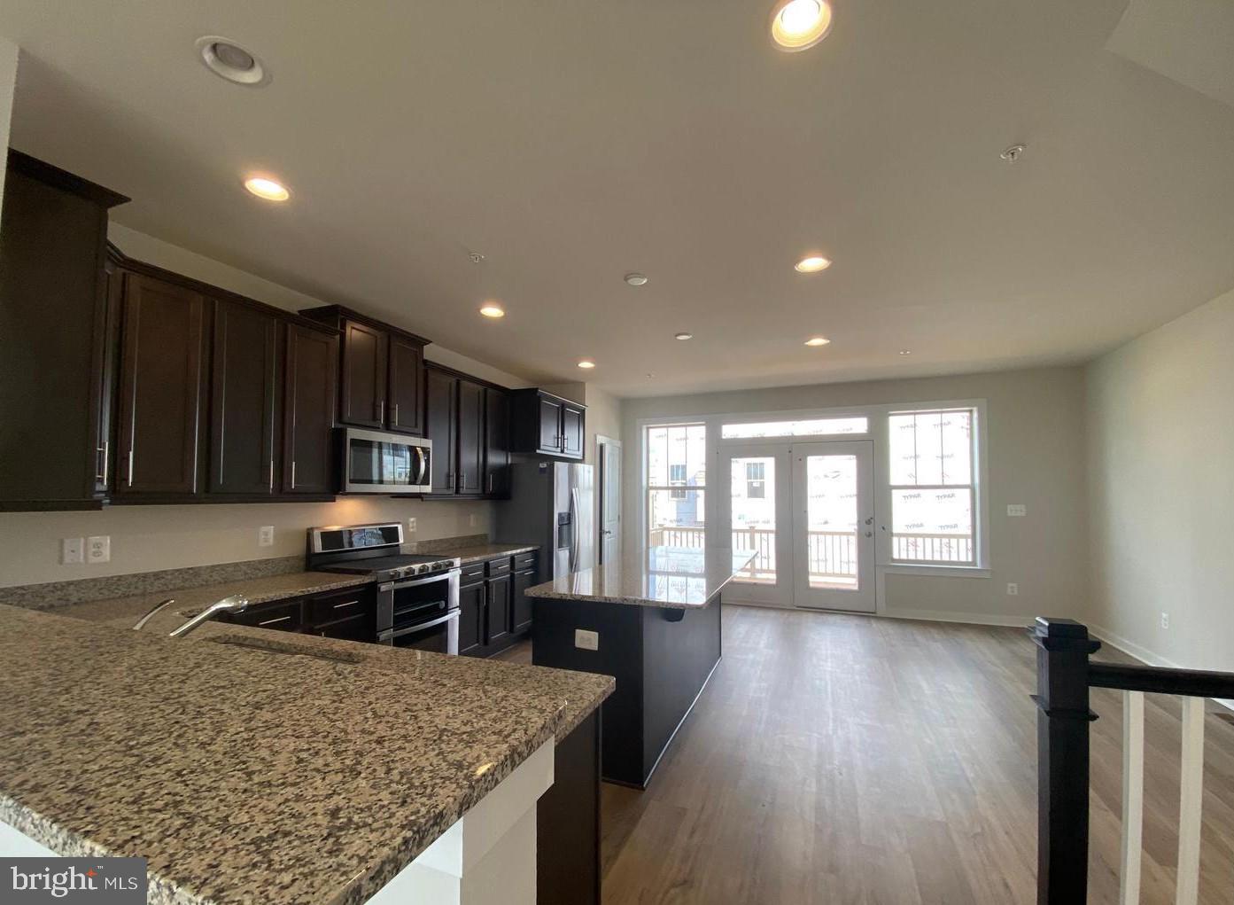 3639 Stone Barn Drive Frederick, MD 21704 - Photo 4 of 21 a kitchen with stainless steel appliances granite countertop a sink stove and wooden floor