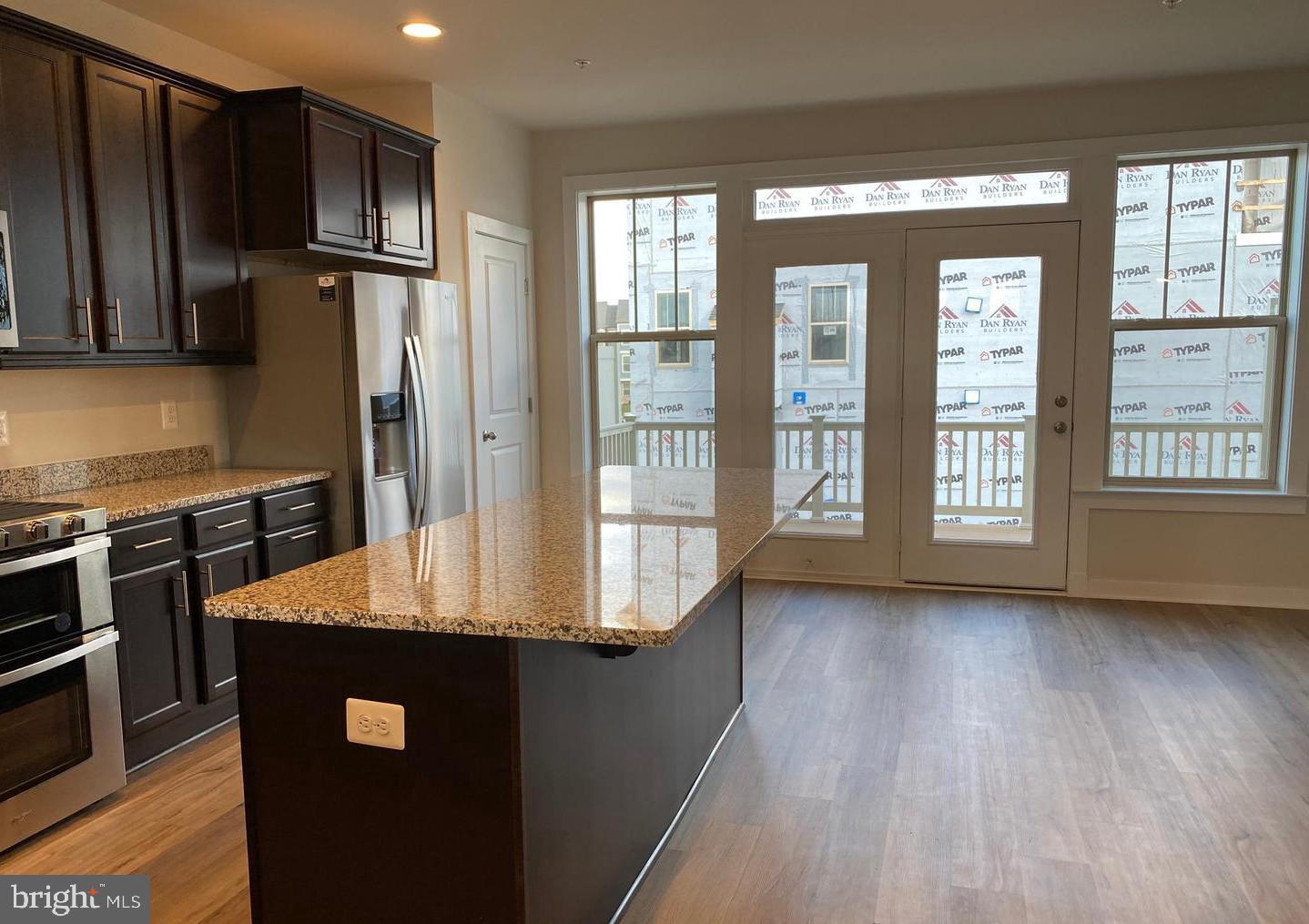 3639 Stone Barn Drive Frederick, MD 21704 - Photo 5 of 21 a kitchen with stainless steel appliances granite countertop a refrigerator a stove and a wooden floors