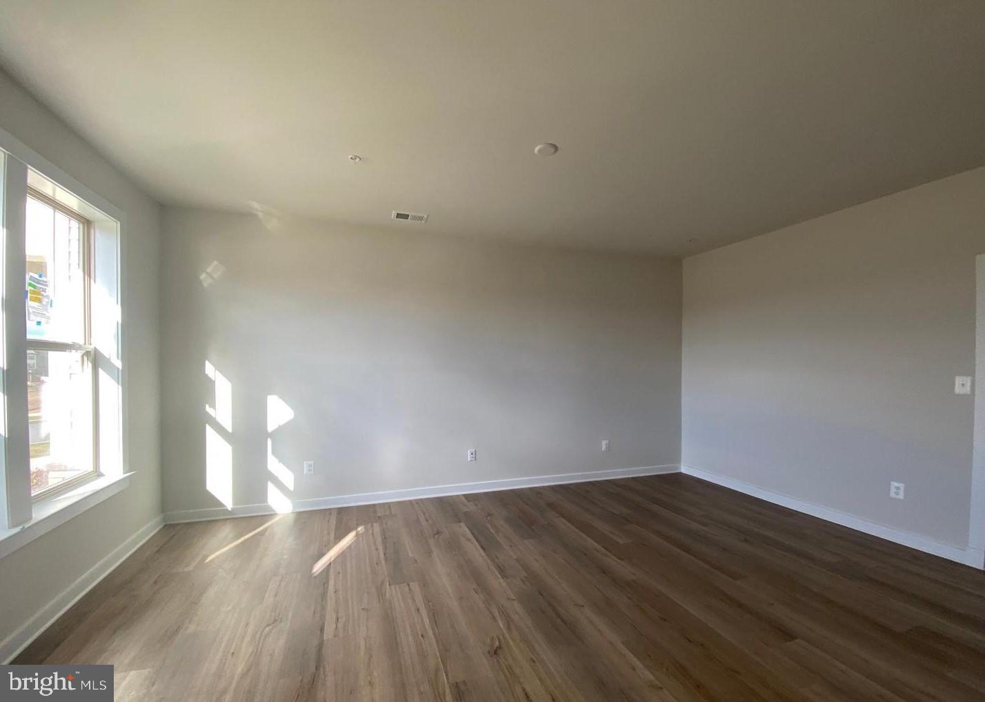 3639 Stone Barn Drive Frederick, MD 21704 - Photo 9 of 21 an empty room with wooden floor and windows