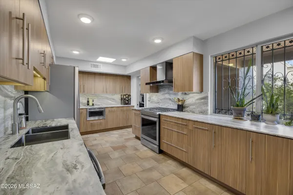 a large kitchen with stainless steel appliances lots of counter space and a sink