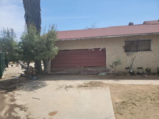 a front view of a house with a yard and covered with snow