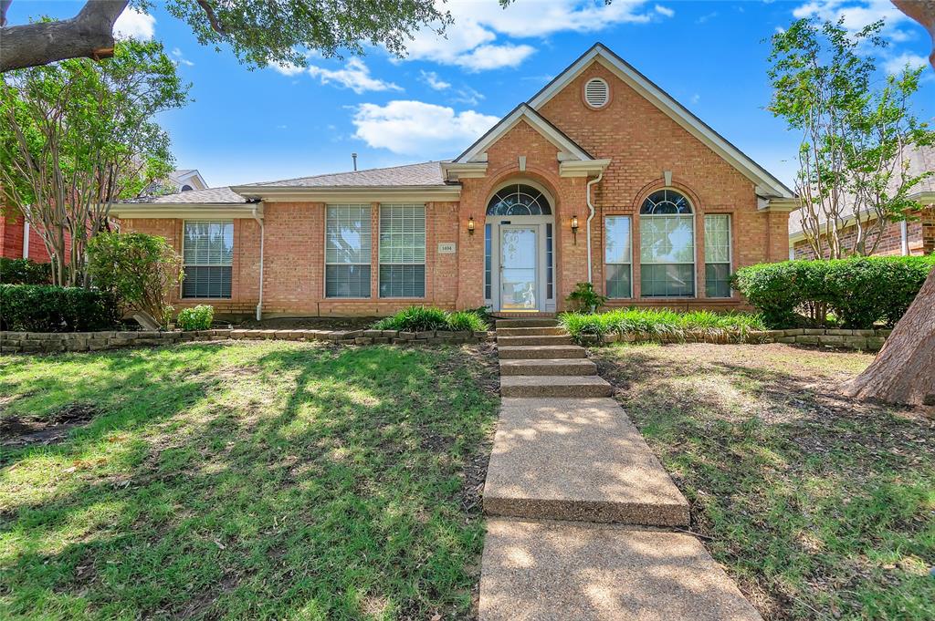 1404 Ranch Hill Drive Irving, TX 75063 - Photo 1 of 31 Brick facade residence featuring an arched entry, multiple arched windows, and a stepped concrete pathway