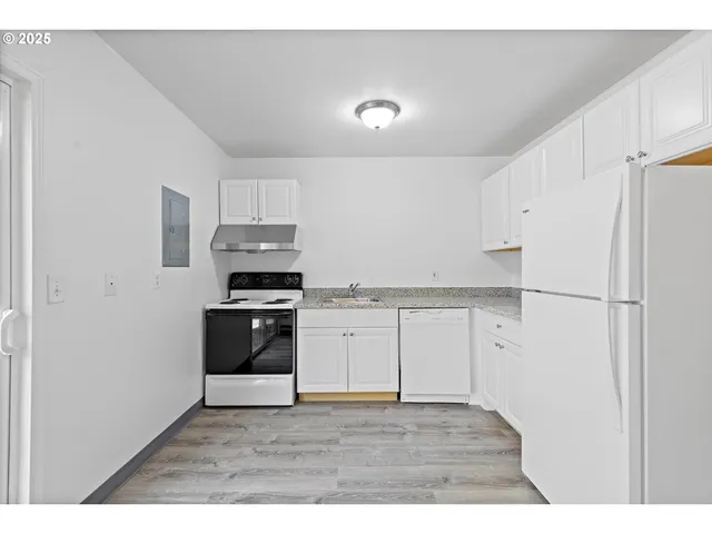 a kitchen with granite countertop white cabinets and stainless steel appliances