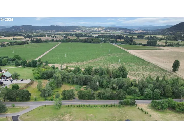 an aerial view of field with residential house