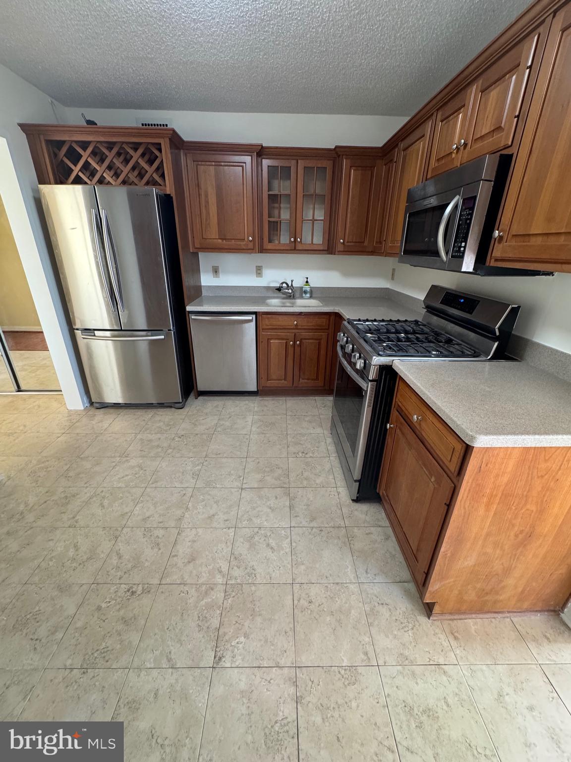 5225 Pooks Hill Road, Unit 1128S Bethesda, MD 20814 - Photo 57 of 61 a kitchen with stainless steel appliances granite countertop a stove top oven a sink and a refrigerator