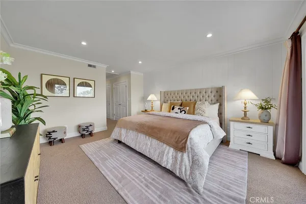a bedroom with bed and paintings on the dresser