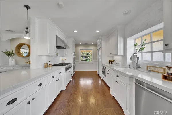 a large kitchen with kitchen island wooden floors and stainless steel appliances