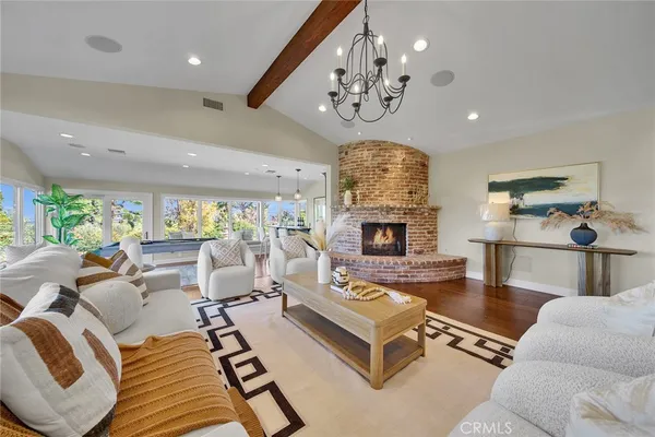a living room with furniture chandelier and fireplace