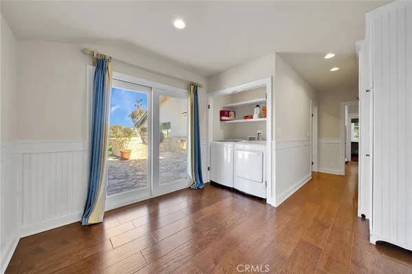a view of a hallway with wooden floor and cabinet