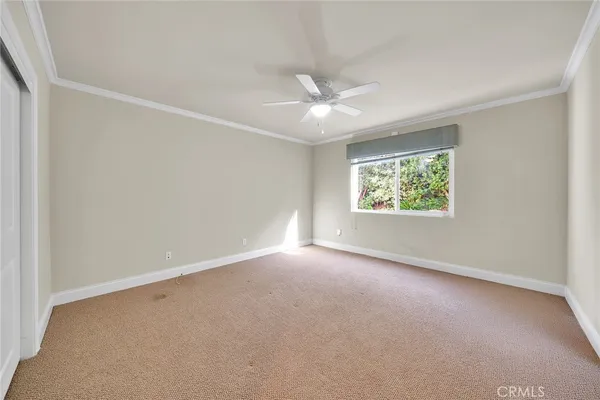 an empty room with a window and a fan