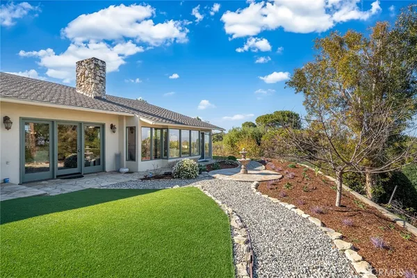 a view of a house with backyard sitting area and garden