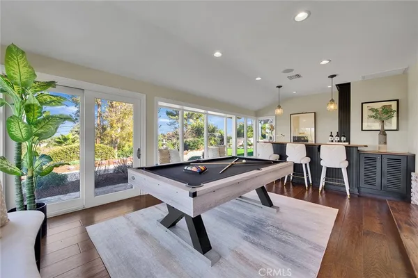 a room with lots of furniture wooden floor and a potted plant
