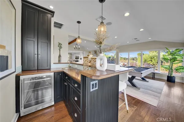 a kitchen with stainless steel appliances granite countertop a sink a stove and a wooden floor