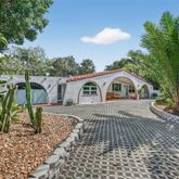 a front view of a house with a yard and trees