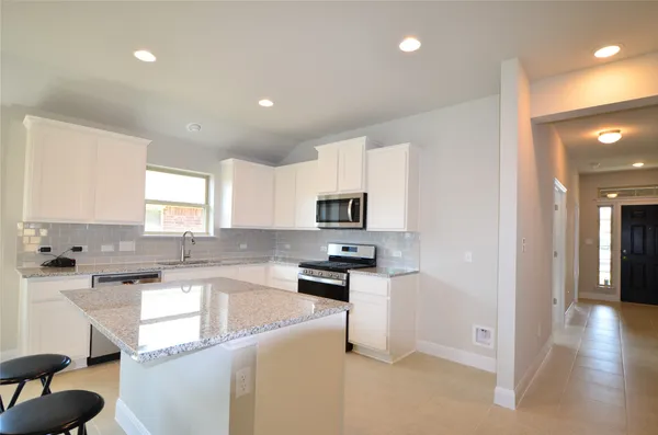 a kitchen with granite countertop a sink and cabinets