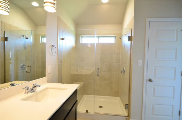 a bathroom with a shower sink vanity and mirror