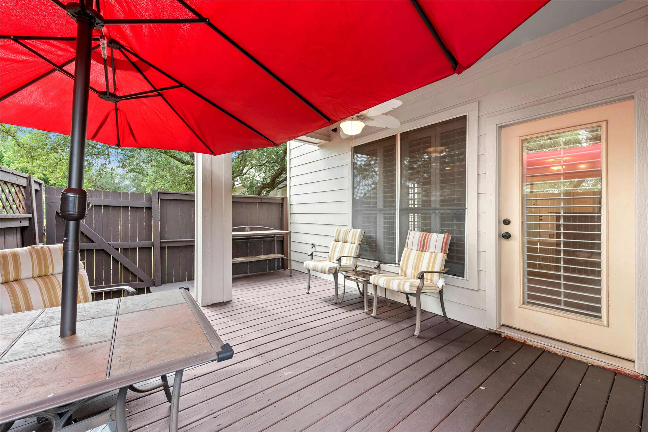7500 Shadowridge Run, Unit 34 Austin, TX 78749 - Photo 27 of 27 a patio with wooden floor a yard a table and chairs