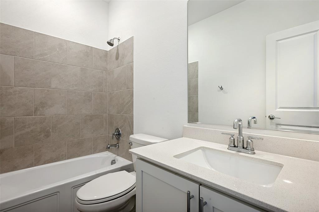 108 Invermore Drive Little Elm, TX 75068 - Photo 14 of 19 a bathroom with a granite countertop sink a toilet and shower