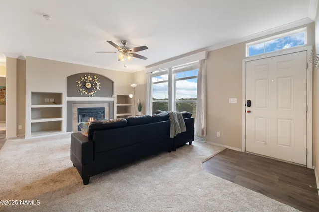 a living room with furniture a clock and a ceiling fan