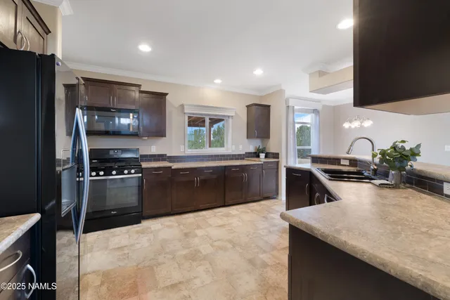 a kitchen with stainless steel appliances kitchen island granite countertop a sink a stove top oven a refrigerator and a oven