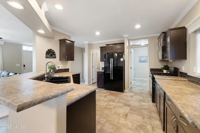 a large kitchen with stainless steel appliances a sink a stove and a refrigerator