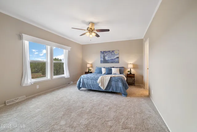 a spacious bedroom with a bed and a chandelier