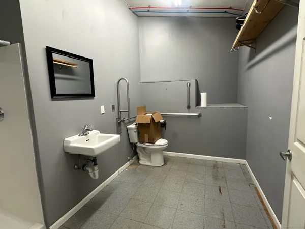 a bathroom with a sink toilet and a mirror