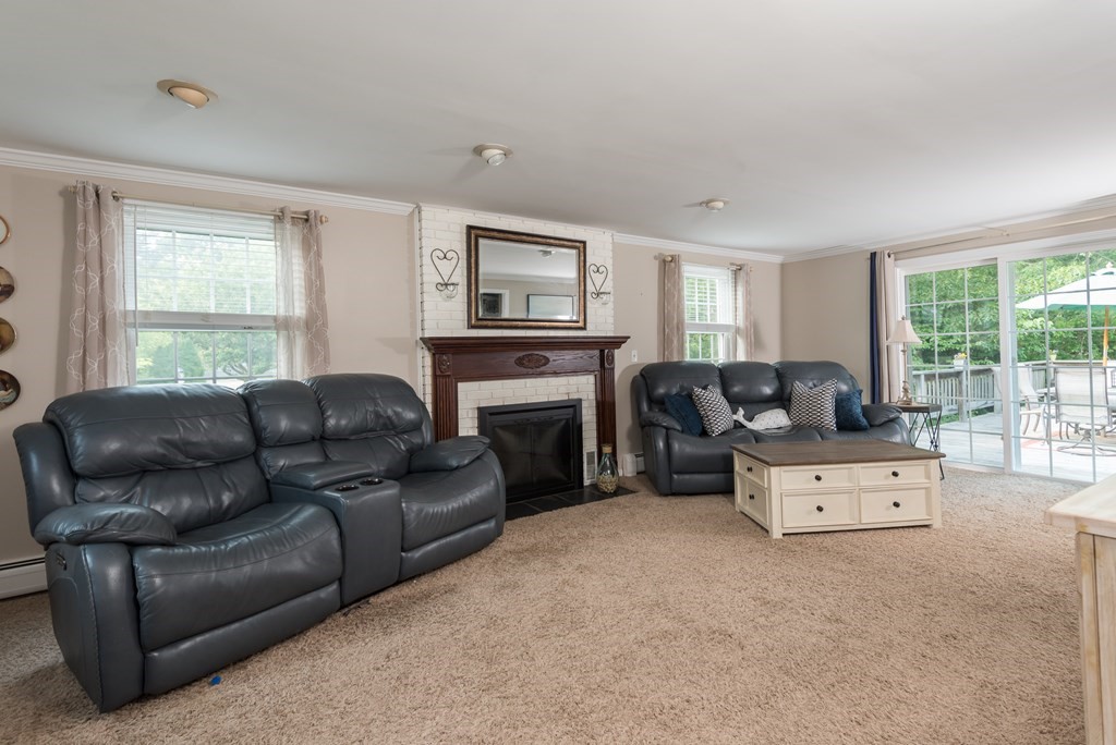 324 Nye Road Barnstable, MA 02632 - Photo 7 of 37 a living room with furniture a fireplace and a large window