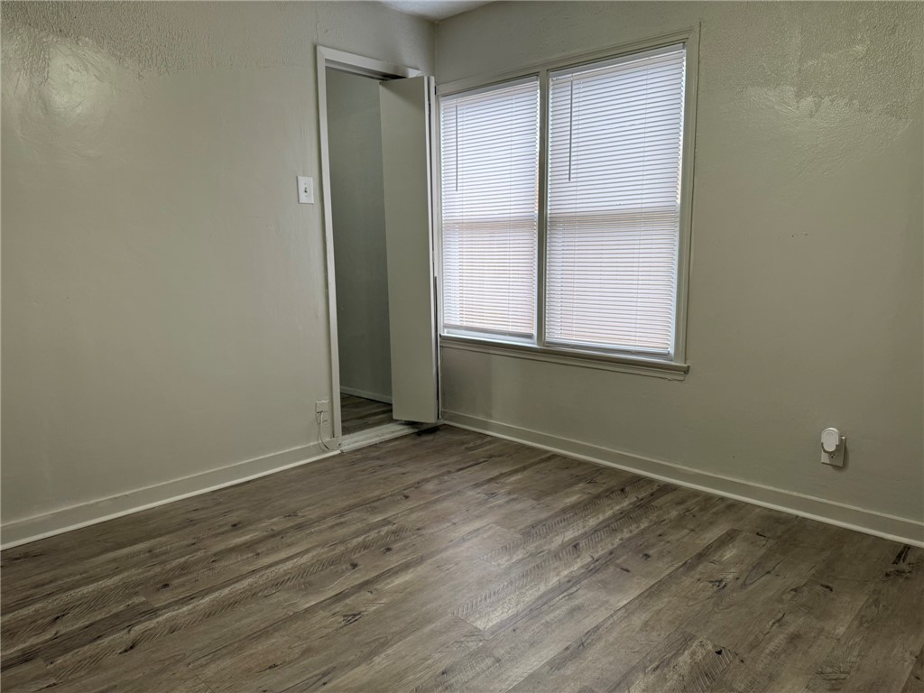 1302 East 23rd Street Bryan, TX 77803 - Photo 20 of 23 an empty room with wooden floor and windows