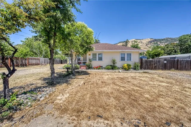 a view of a house with backyard and sitting area