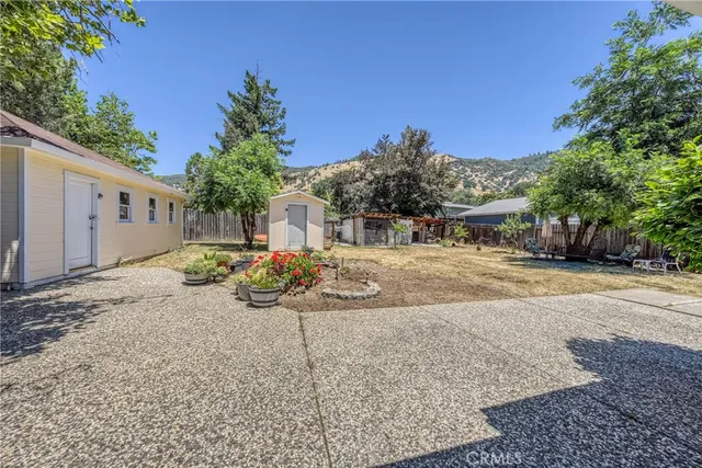 an aerial view of residential houses with outdoor space and trees