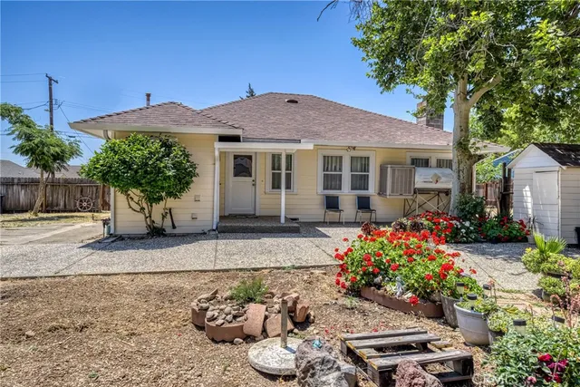 a front view of a house with a yard and a garden