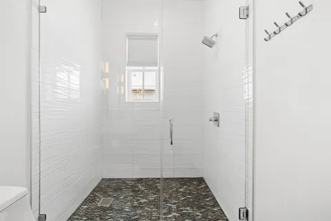 a bathroom with a sink a toilet and shower