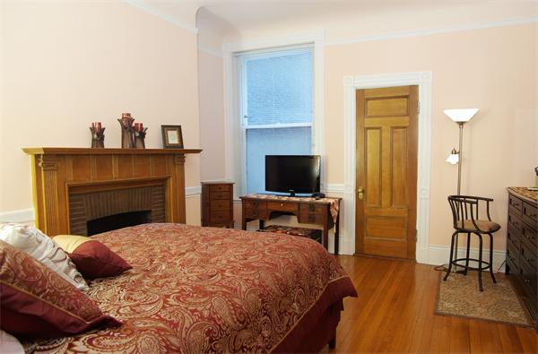 479 Beacon Street, Unit 11 Boston, MA 02115 - Photo 4 of 8 a bedroom with a bed and a television