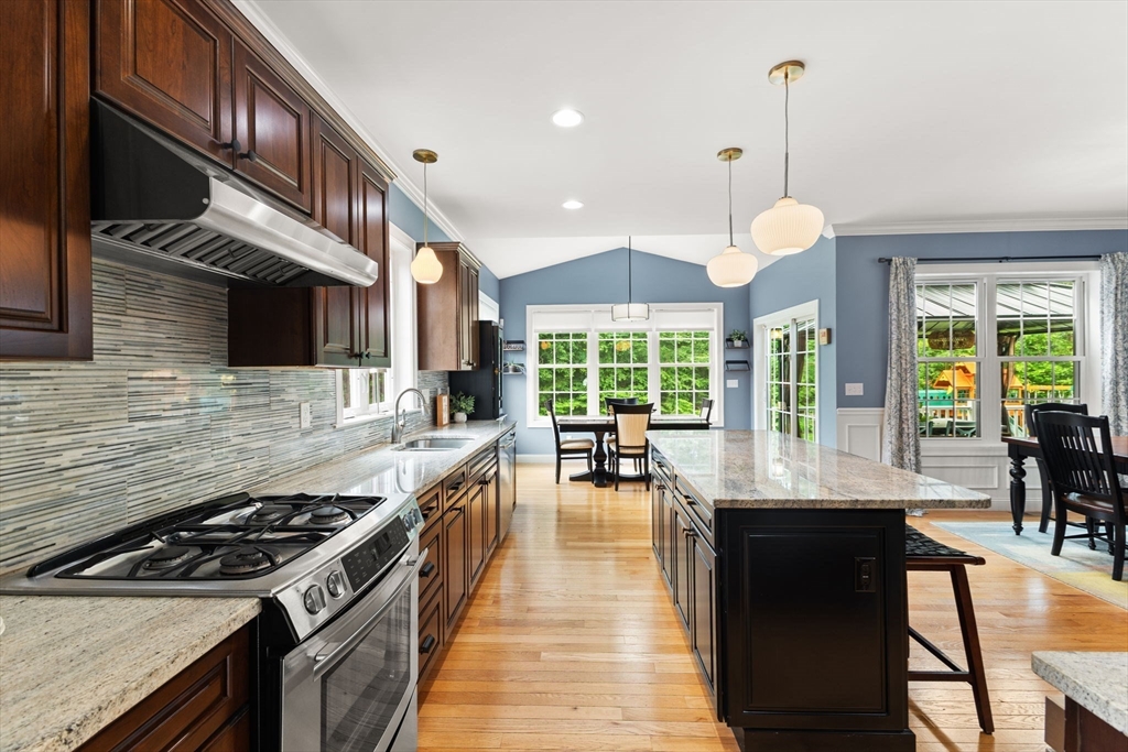 6 Jacoby Way Seekonk, MA 02771 - Photo 11 of 42 a kitchen with stainless steel appliances granite countertop a stove a sink dishwasher a dining table and chairs with wooden floor