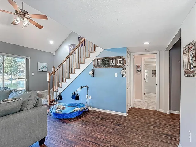 a kitchen with stainless steel appliances granite countertop wooden floor a stove a sink dishwasher a dining table and chairs with wooden floor