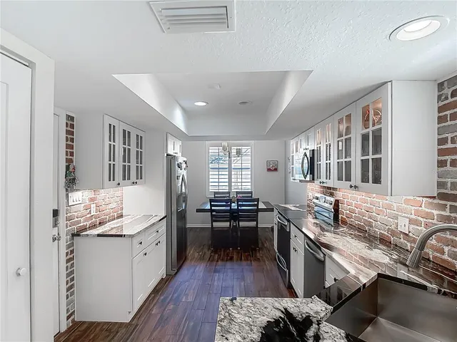 a kitchen with granite countertop a sink and cabinets