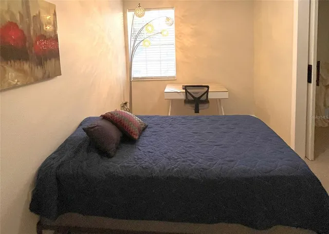 a bedroom with a bed and a large window