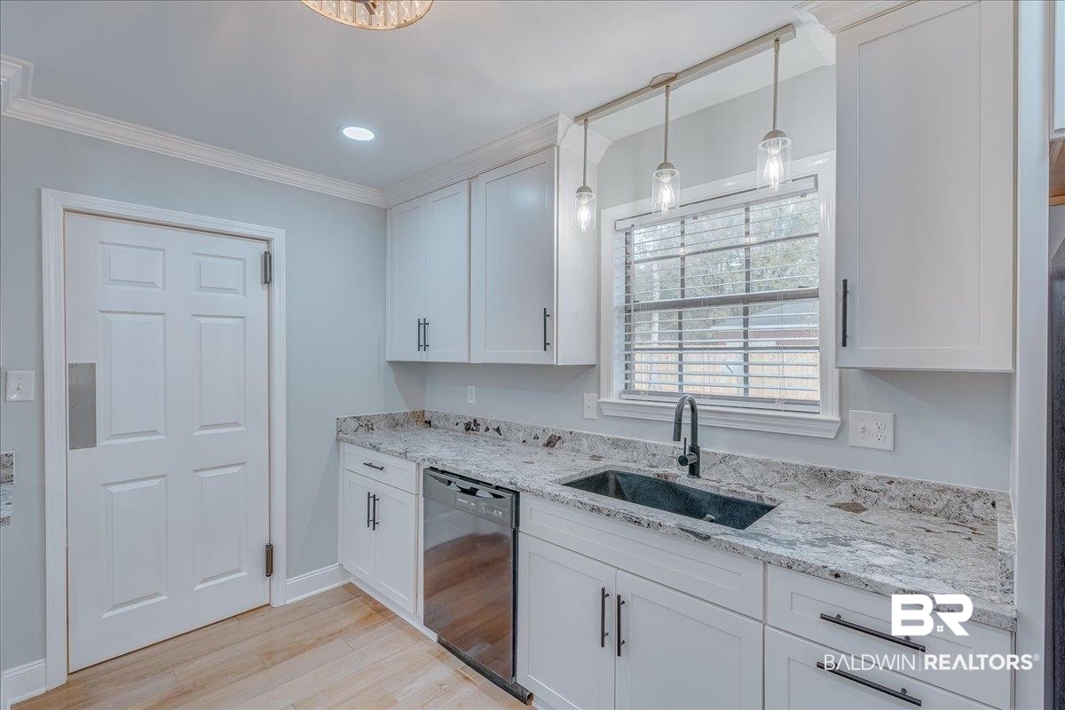 440 Dykes Road Mobile, AL 36608 - Photo 10 of 49 Kitchen featuring crown molding, dishwasher, light wood-style floors, white cabinetry, and a sink