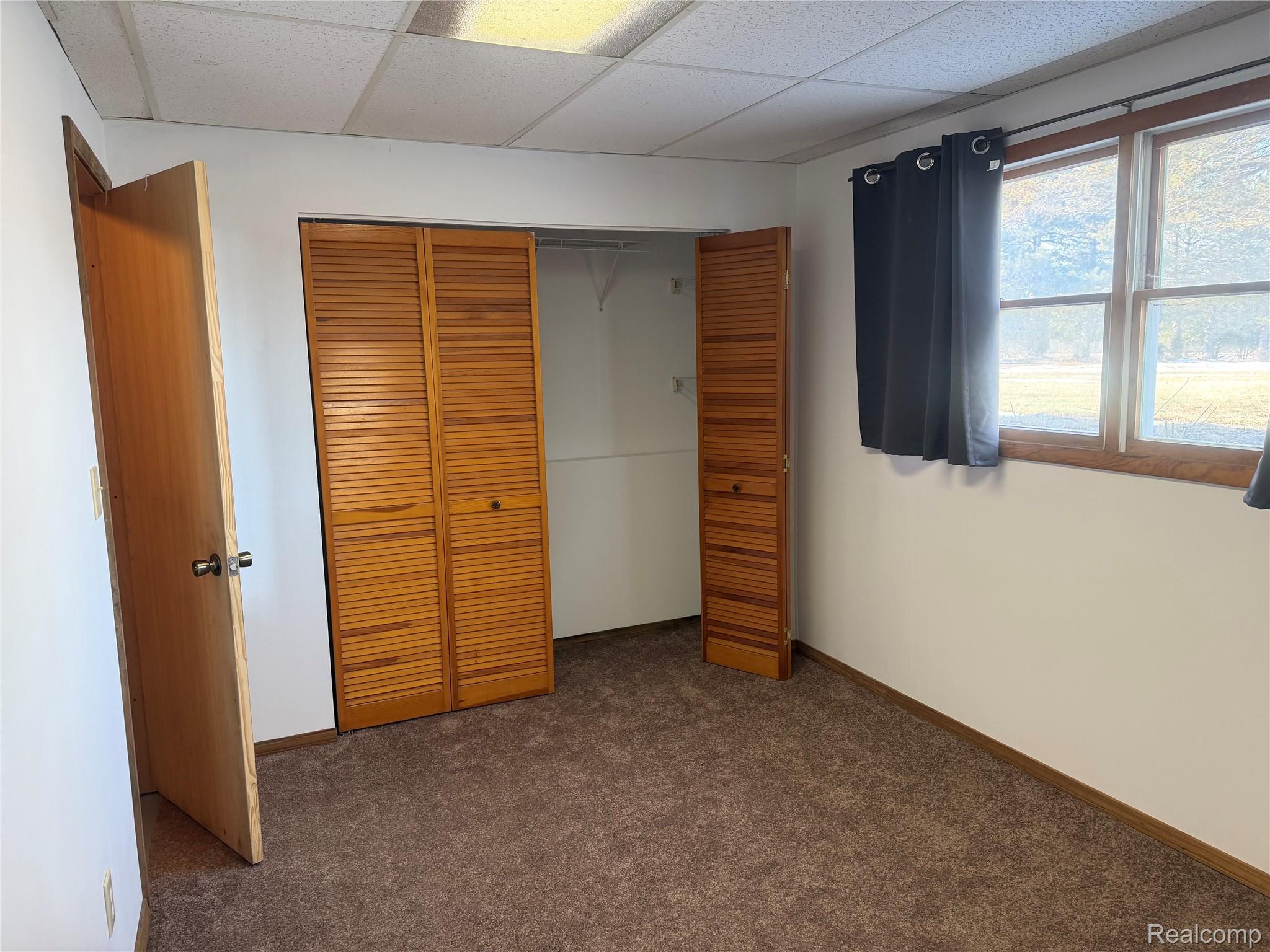5749 Leix Road Mayville, MI 48744 - Photo 29 of 44 Unfurnished bedroom featuring a paneled ceiling, carpet floors, and a closet
