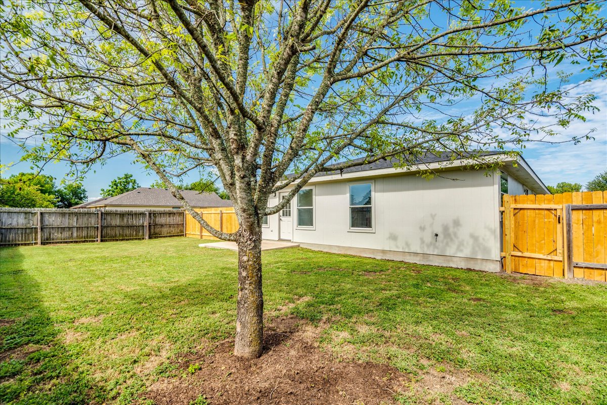 100 Easy Street Hutto, TX 78634 - Photo 28 of 36 A generous backyard offers a private outdoor sanctuary, fully enclosed by a wood fence.