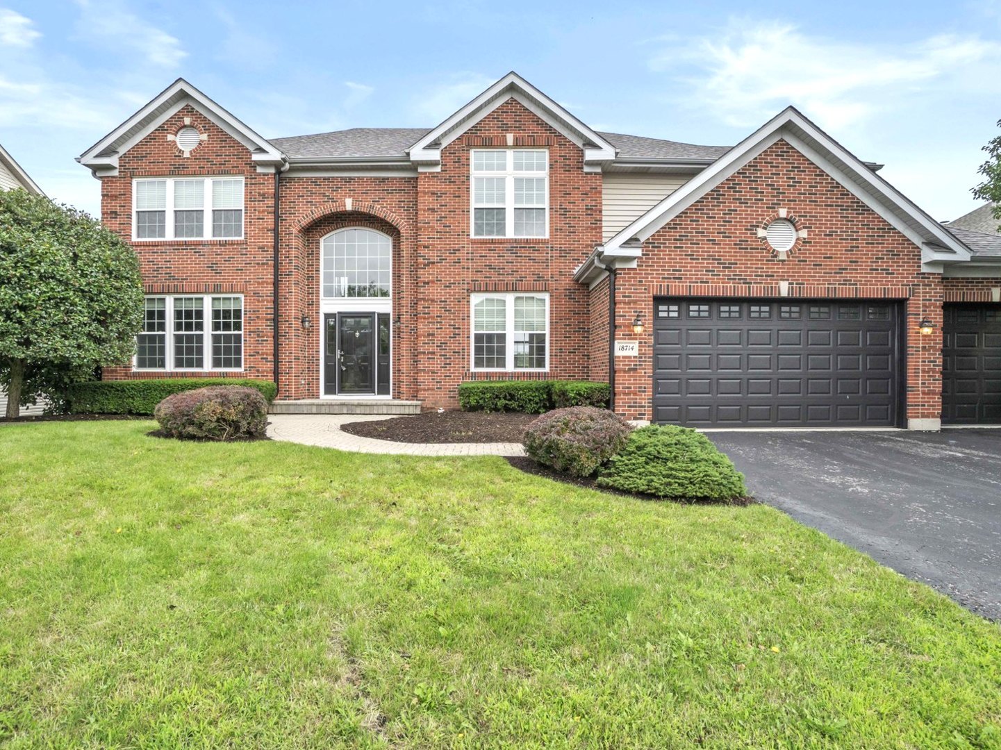 a front view of a house with a yard and garage