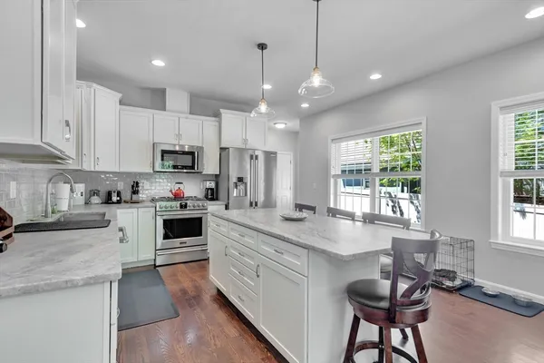 a kitchen with stainless steel appliances granite countertop a stove a sink a oven a dining table and chairs