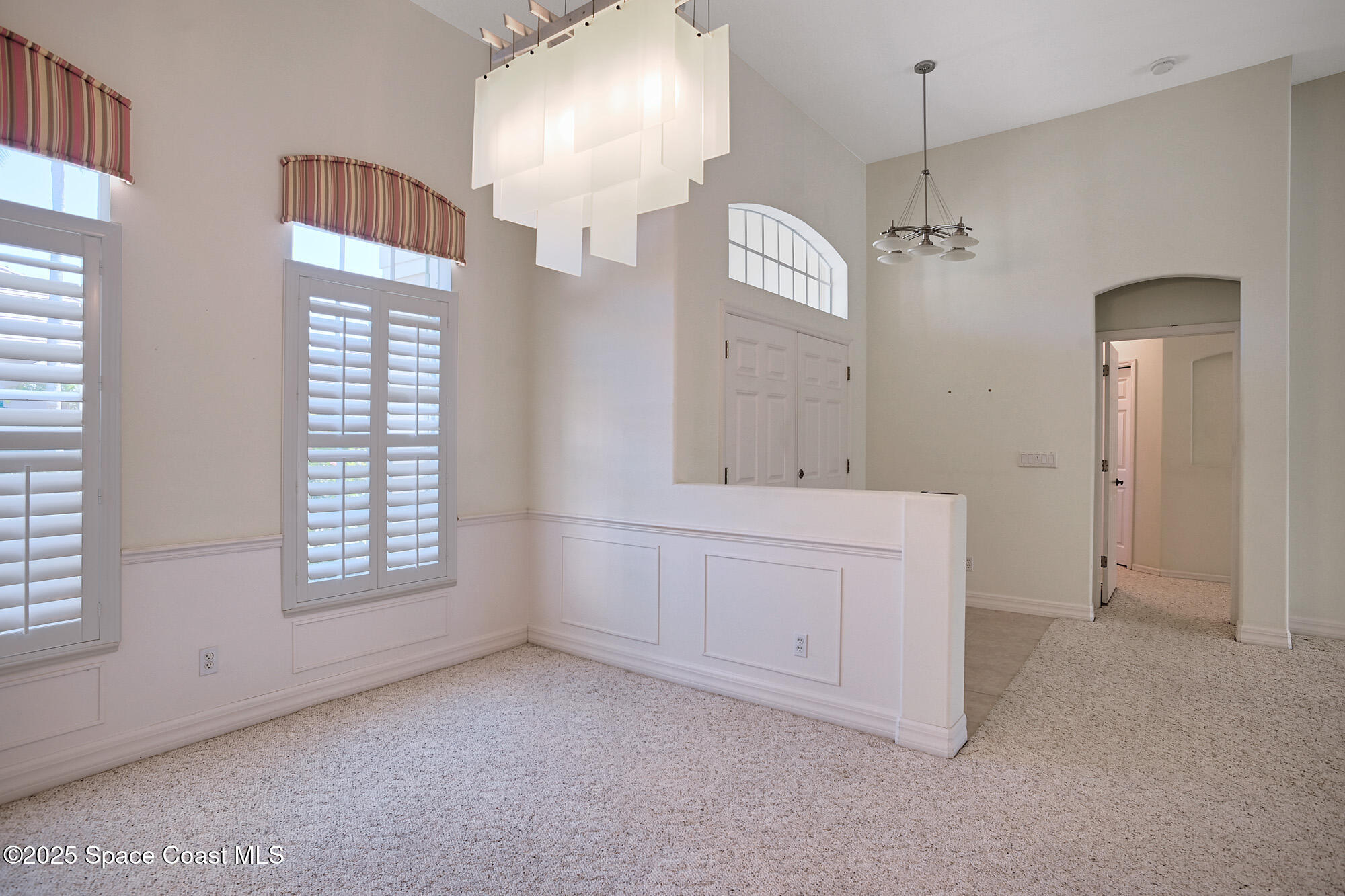 5357 Solway Drive Melbourne Beach, FL 32951 - Photo 6 of 31 an empty room with chandelier and mirror